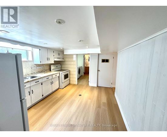 A kitchen with white cabinets and a wooden floor.