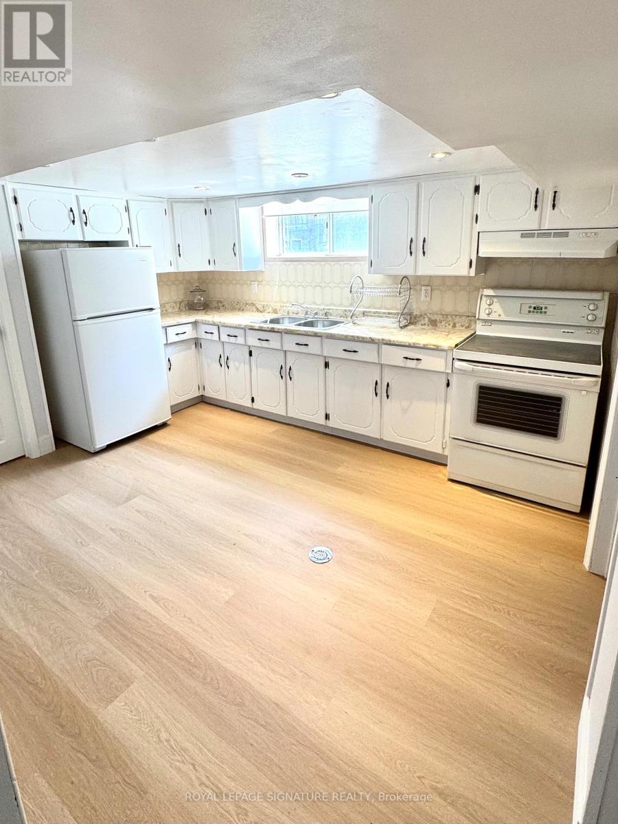 A kitchen with white cabinets and appliances.