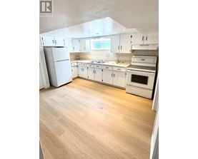 A kitchen with white cabinets and appliances.