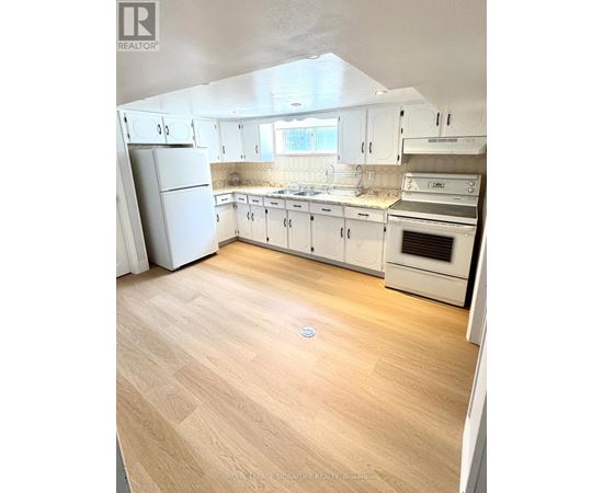 A kitchen with white cabinets and appliances.
