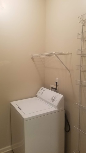 A white washing machine in a small laundry room.