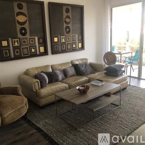 A living room with a couch, chair, and two wall art pieces.