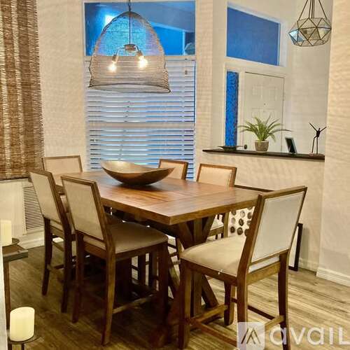 A dining room with a wooden table and chairs.