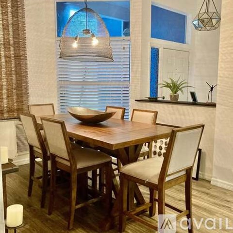 A dining room with a wooden table and chairs.