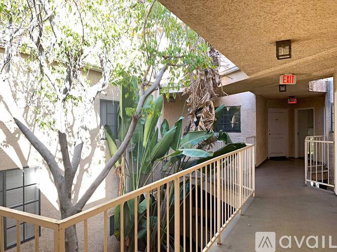 A balcony with a railing and a tree in front of a building.