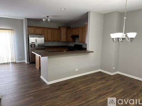 A kitchen with wooden cabinets and a stainless steel refrigerator.