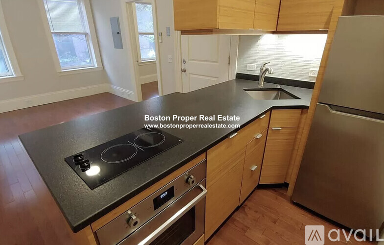 A kitchen with a black countertop and wooden cabinets.