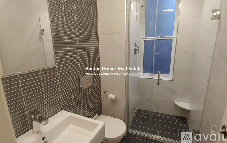 A bathroom with a toilet, sink, and shower.
