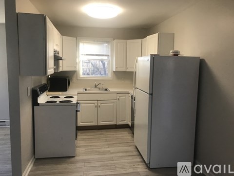 A kitchen with a refrigerator, stove, and sink.