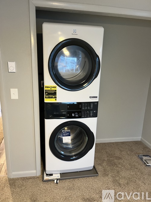 A white front loading washing machine with a black door and control panel.