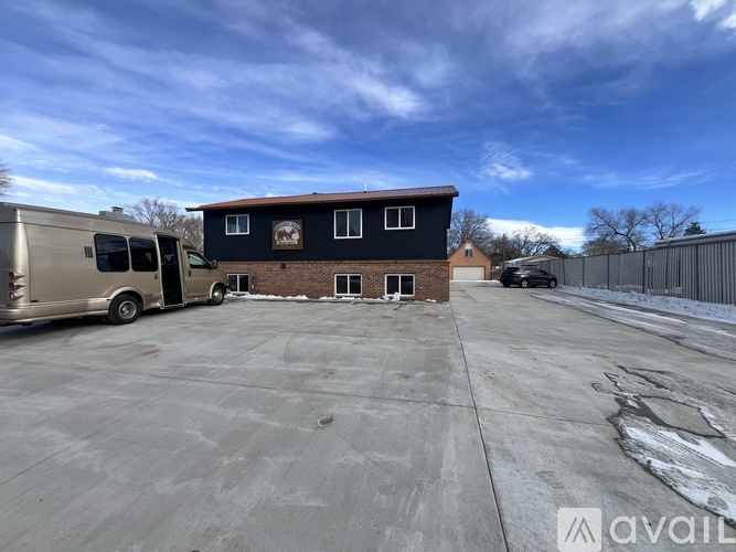 A parking lot with a building and a van.