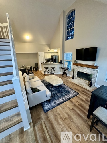 A living room with a fireplace and a television on the wall.