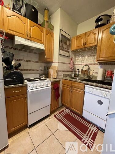 A kitchen with a white stove and a white dishwasher.