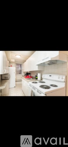 A modern kitchen with white appliances and a stainless steel range hood.