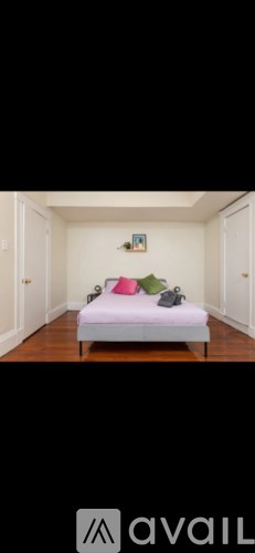 A bedroom with a bed and a painting on the wall.