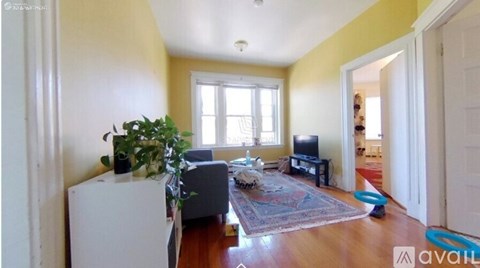 A living room with a grey couch and a white cabinet.