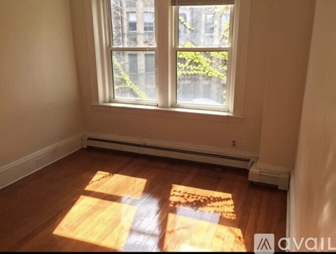 A room with a window and wooden floors.