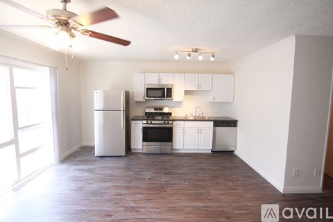 A kitchen with white cabinets and a wood floor.