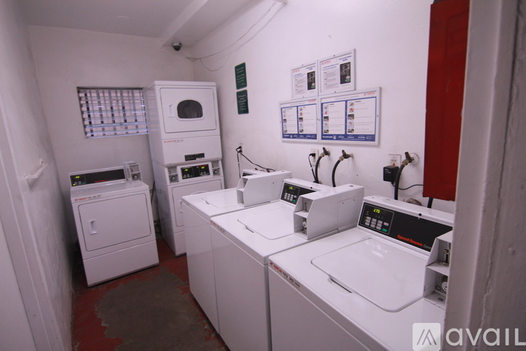 A row of washing machines are lined up in a small room.