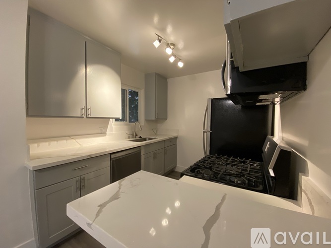 A modern kitchen with a white countertop and a black oven.