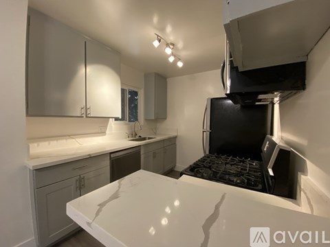 A modern kitchen with a white countertop and a black oven.