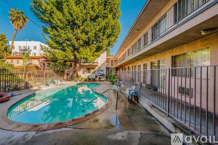 A pool in a courtyard surrounded by trees and buildings.