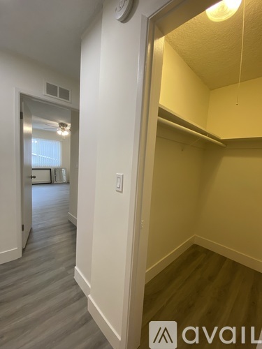 A hallway with a white door and a clock on the wall.