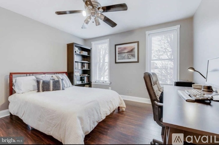 A bedroom with a bed, desk, and chair.