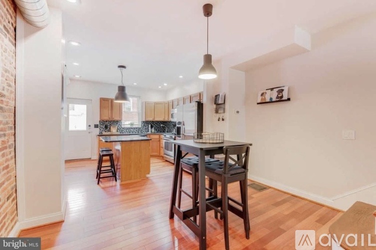 A kitchen with a dining table and chairs.