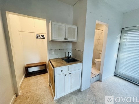 A kitchen area with white cabinets and a black countertop.