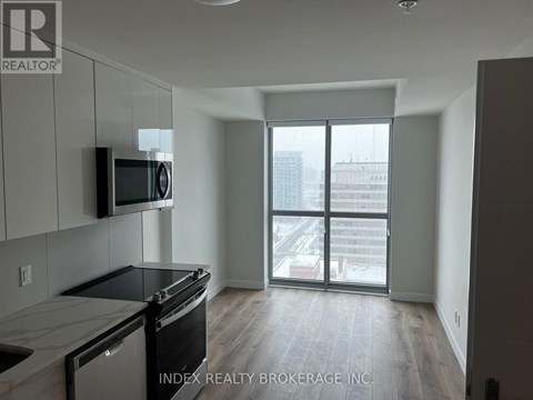 A kitchen with a black stove top oven and microwave above it.