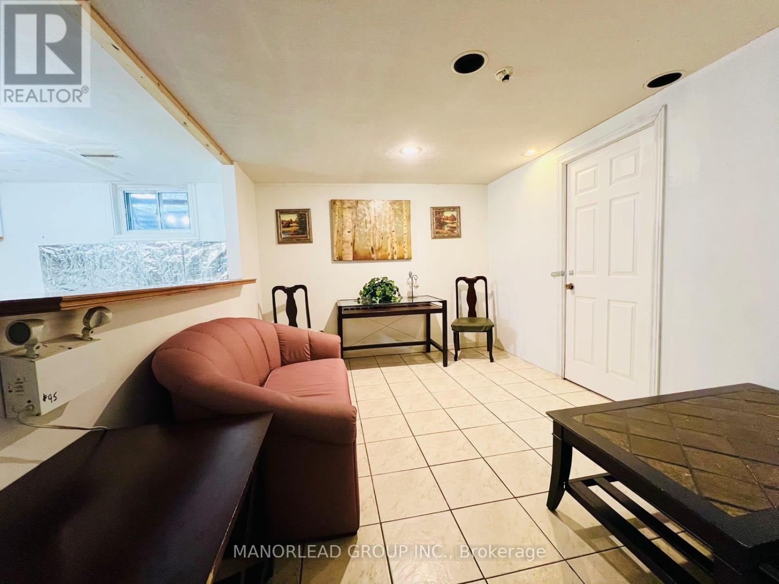 A living room with a brown couch, a wooden table, and a white door.