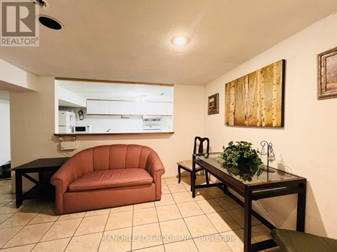 A living room with a brown couch and a glass table.