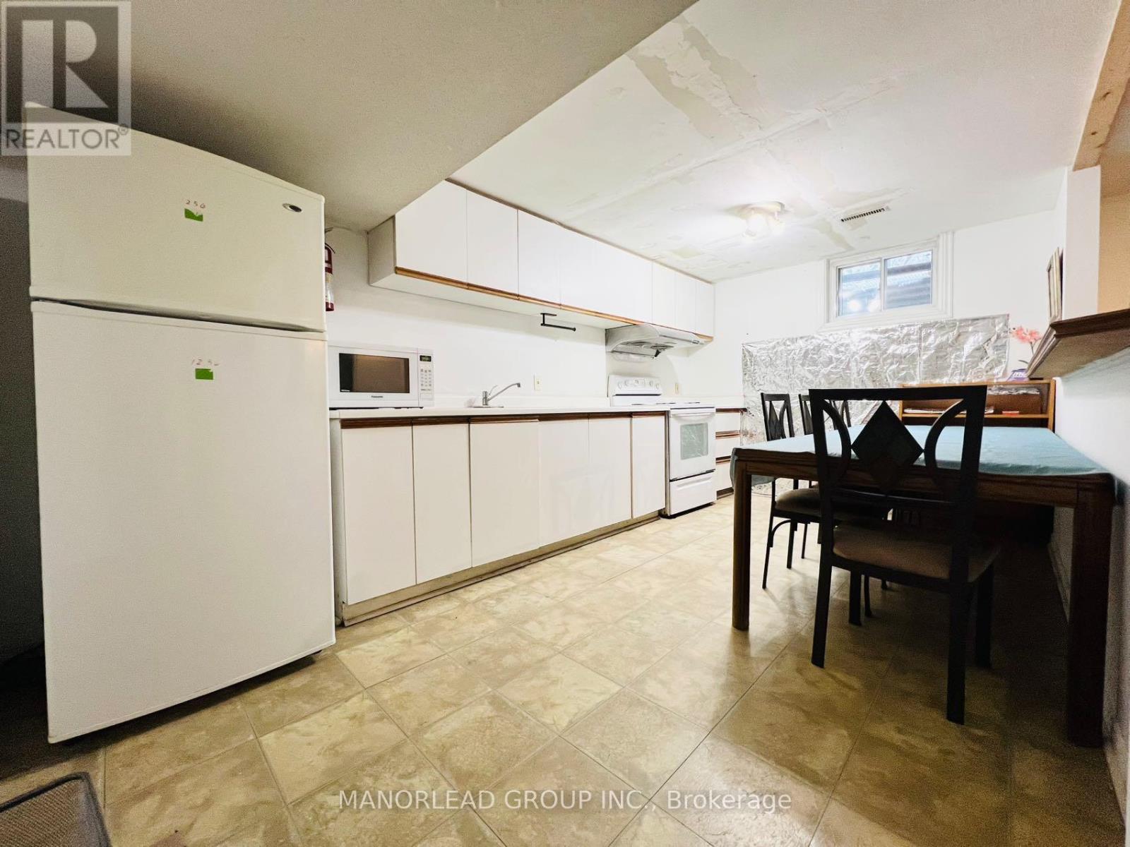 A kitchen with a table and chairs.