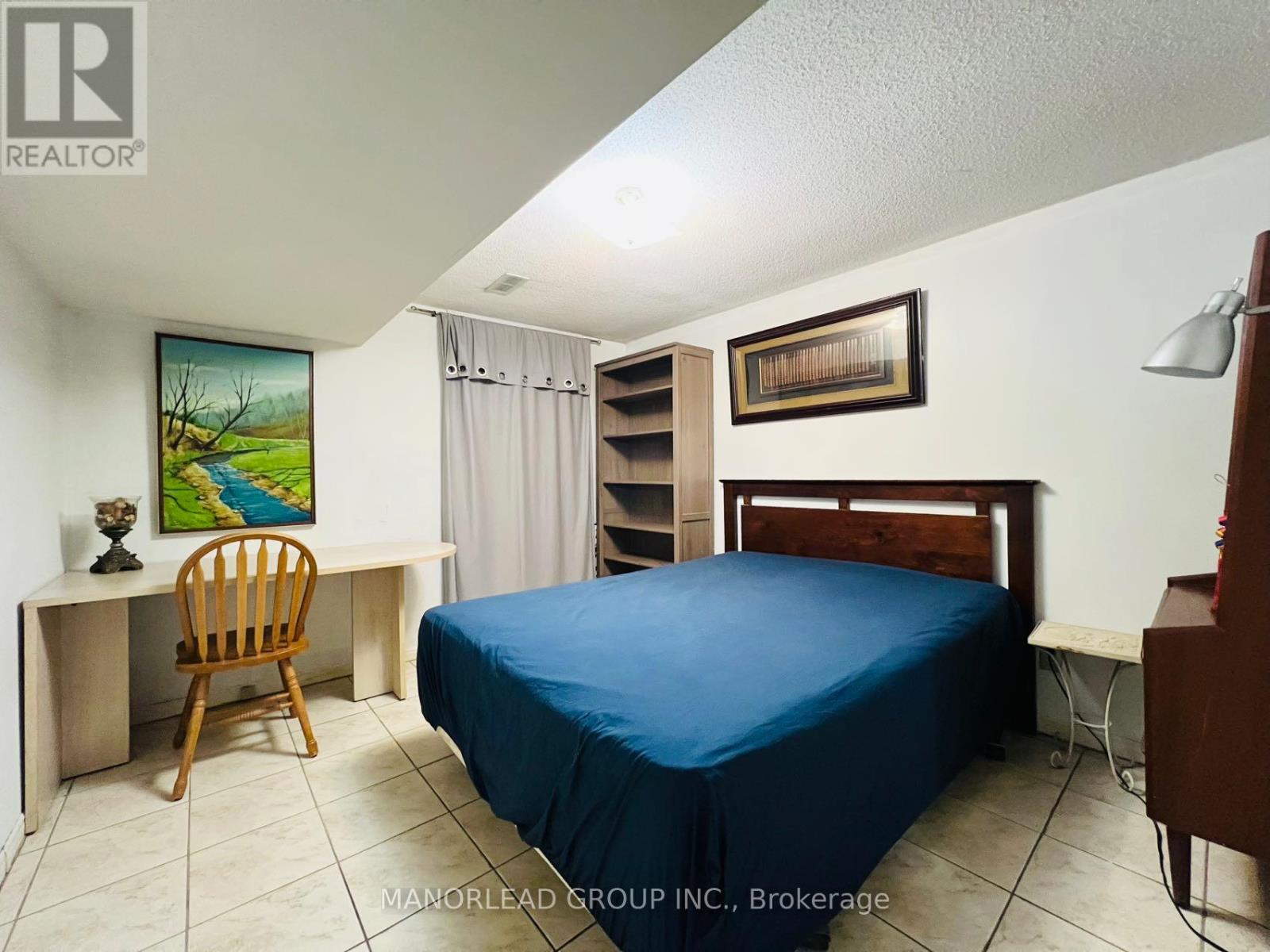 A bedroom with a bed, desk, and chair.