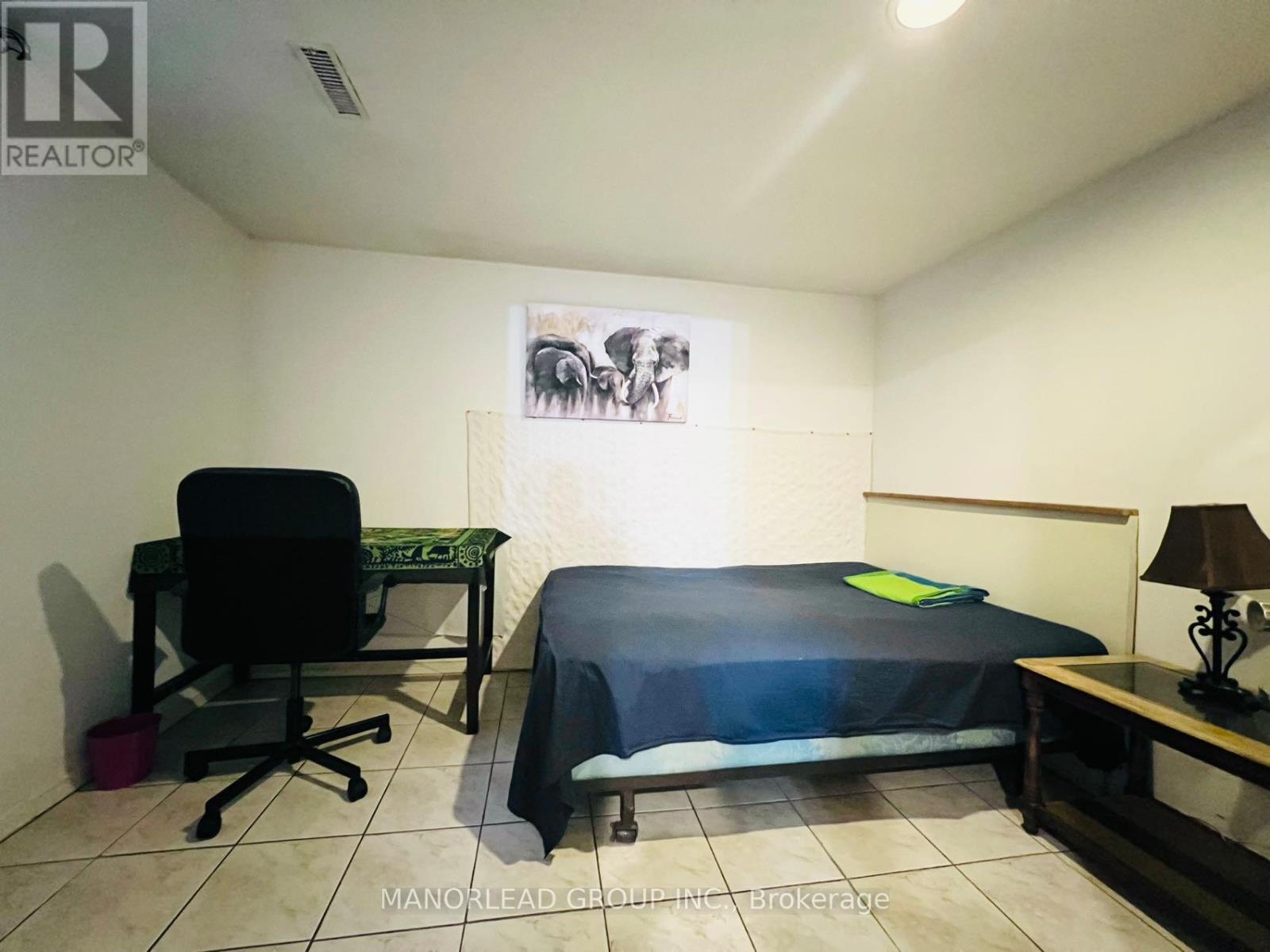 A bedroom with a bed, desk, and chair.