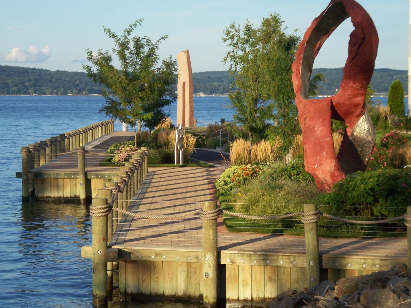 a dock on the water with a sculpture on it