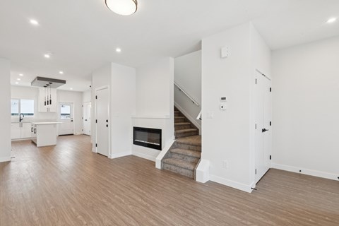 A spacious living room with a staircase leading to the upper floor.