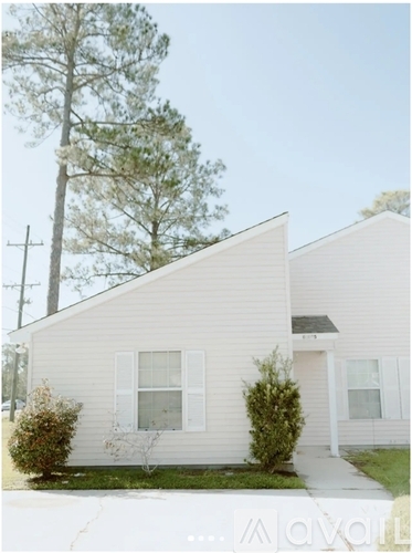 A house with a white siding and a small front yard.