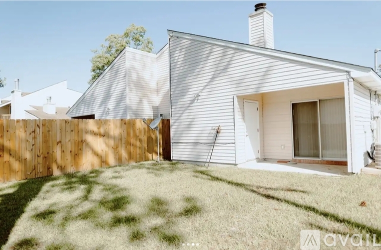 A white house with a wooden fence in front of it.