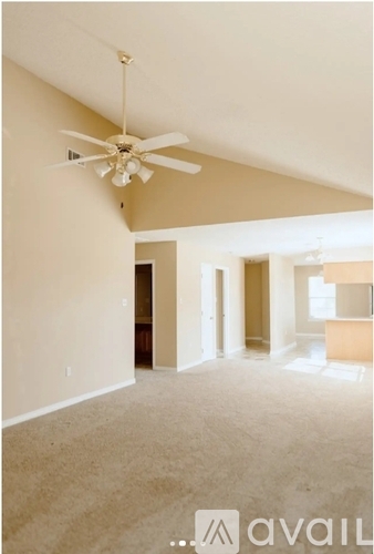 A room with a ceiling fan and carpeted floor.