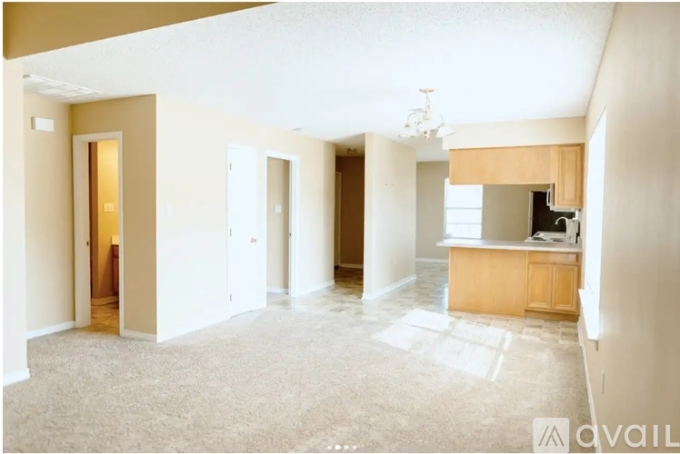 A spacious room with a carpeted floor and a wooden cabinet.