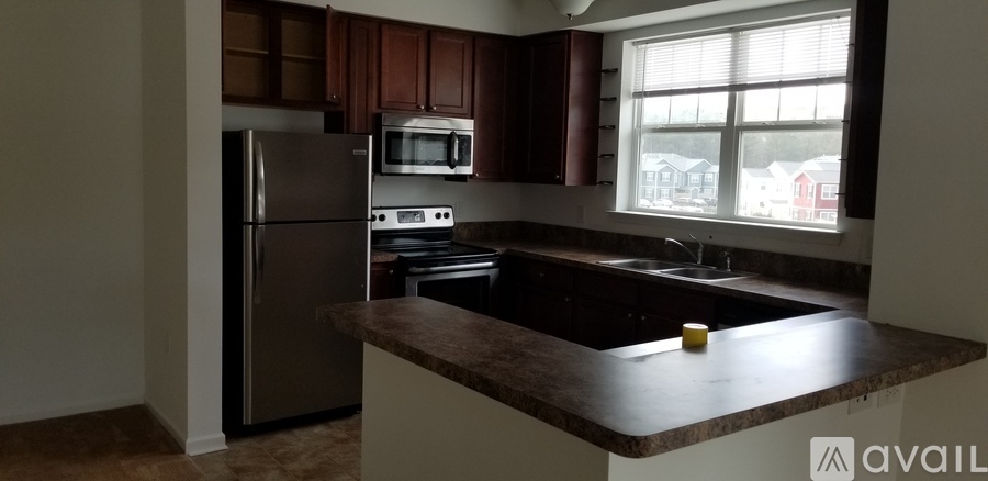 A kitchen with a refrigerator, microwave, oven, and stove.