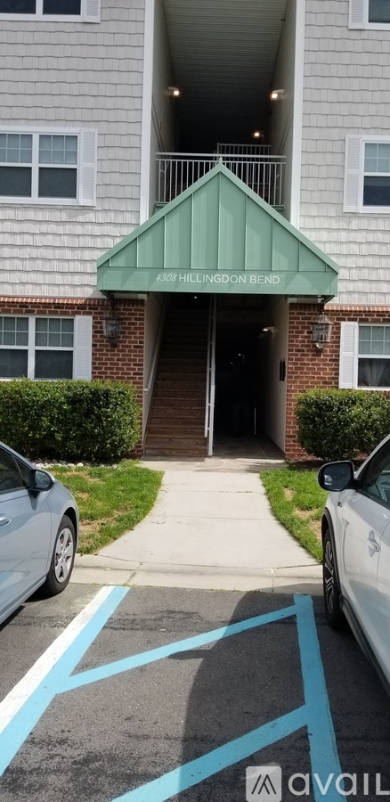 A car is parked in a blue marked spot in front of a building.