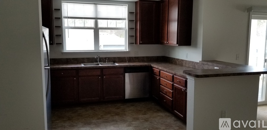 A kitchen with brown cabinets and a window.