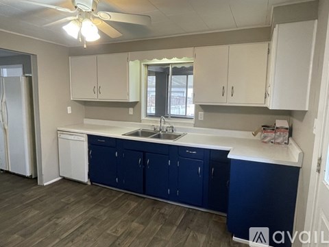 A kitchen with blue cabinets and a white countertop.