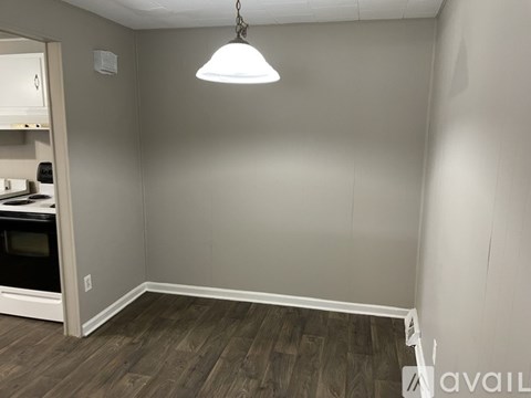 A room with a wooden floor and a hanging light fixture.