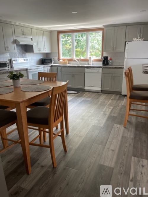 A kitchen with a table and chairs in front of it.