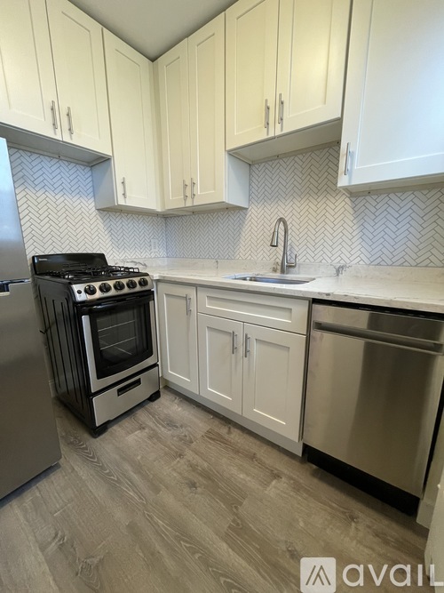 A kitchen with white cabinets and a black stove top oven.