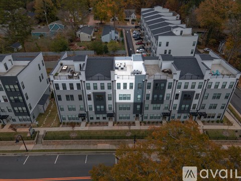A large building complex with multiple buildings and a parking lot in front.